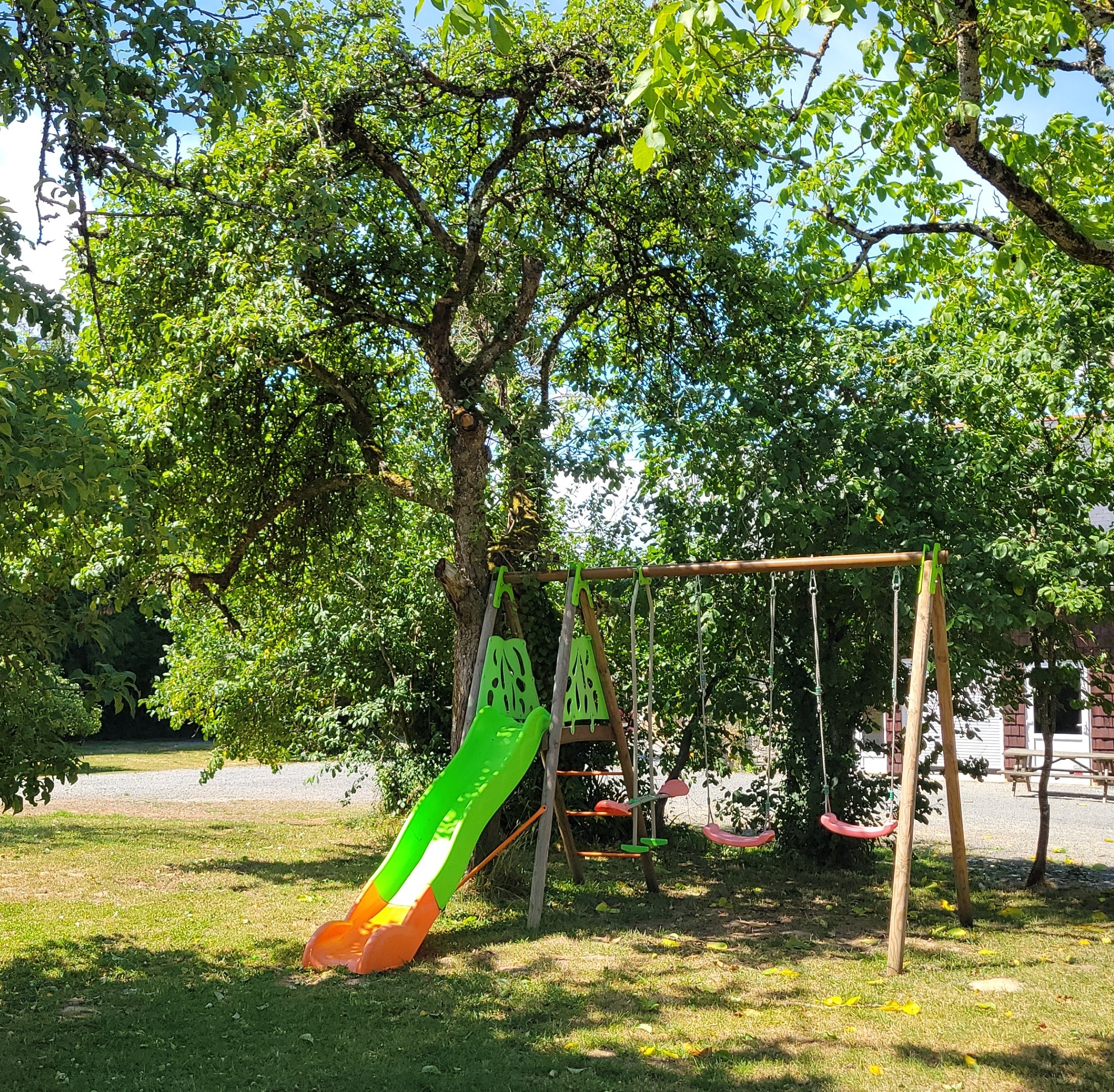 Aire de jeux pour enfants avec balançoire, toboggan et ping-pong au gîte Clos Robin.