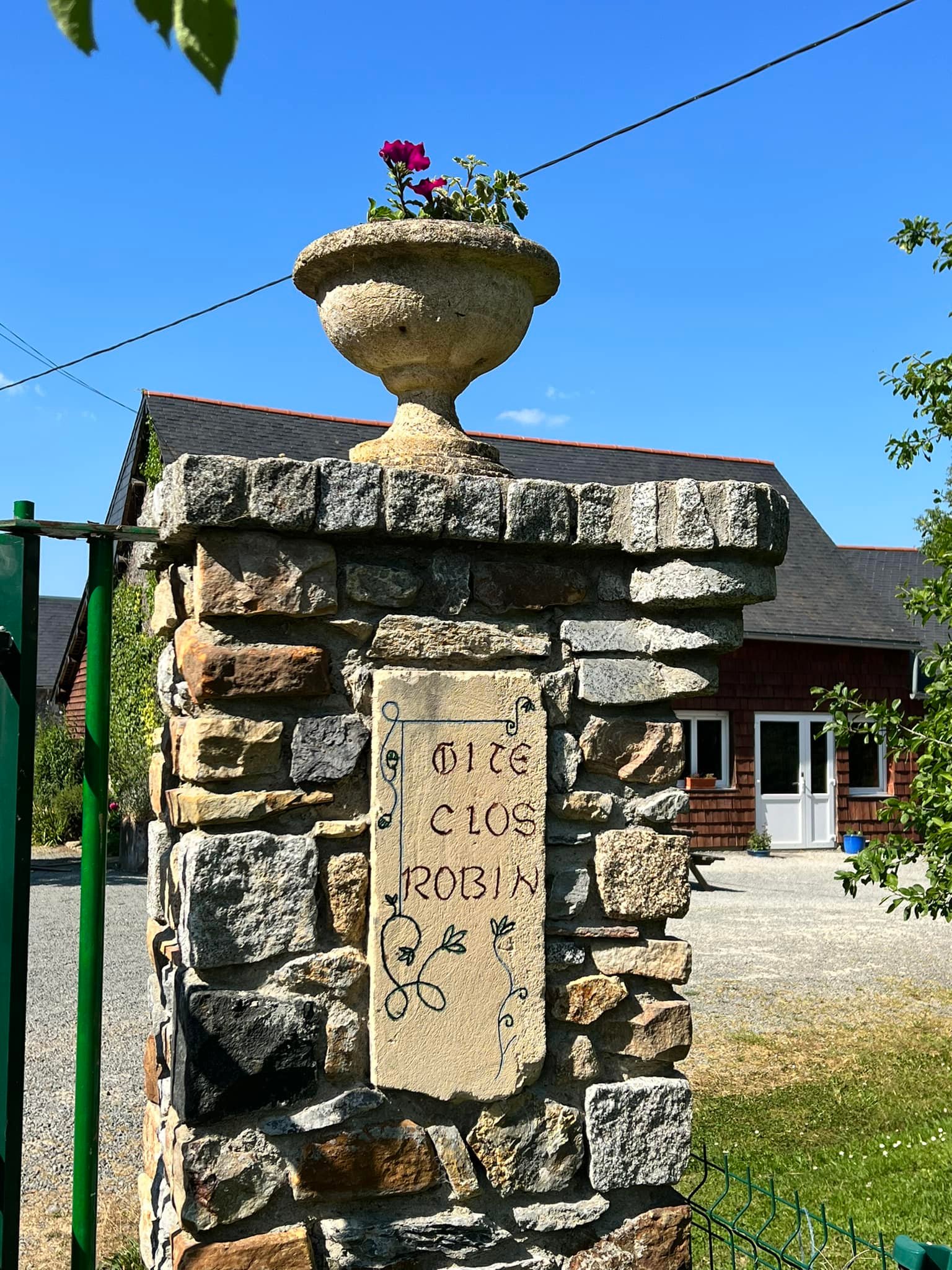 Entrée du gîte en extérieurs avec grand parking privé sécurisé pour bus et voitures en Mayenne.